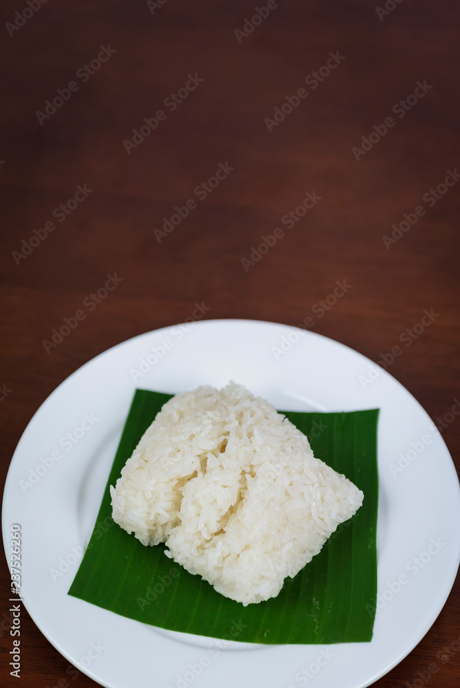Sticky rice on banana leaf and wooden background