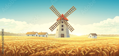 Rural autumn landscape with windmill and wheat field.