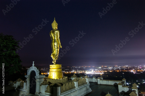Golden buddha statue in Khao Noi temple at twilight, Nan Province, Thailand