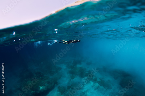 Freediver in wetsuit swimming in the ocean  underwater view