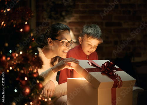 Boy and his mother opening Christmas gifts