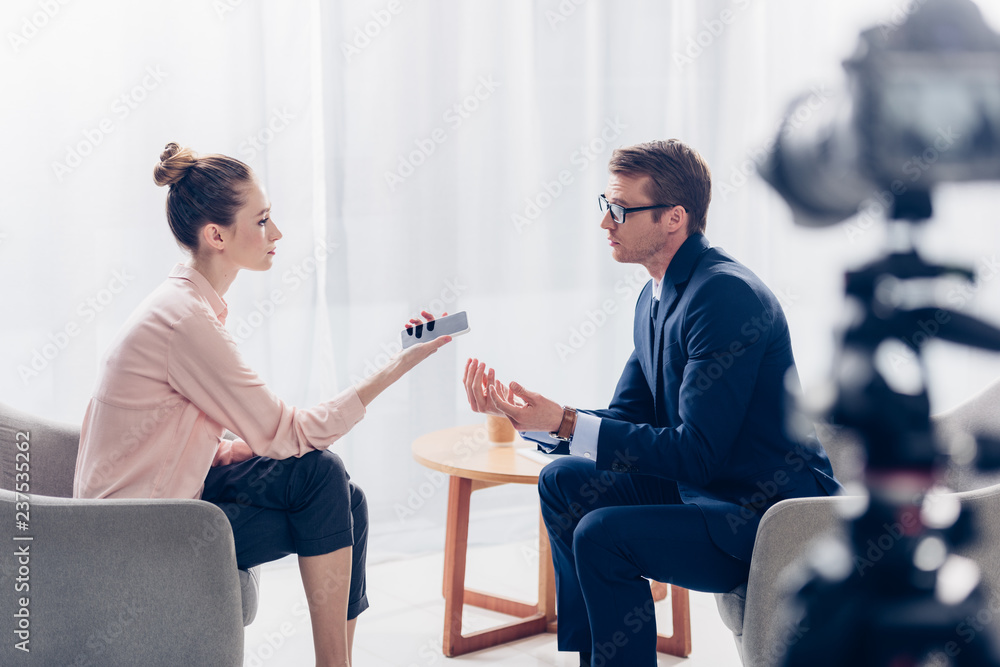 Obraz premium selective focus of handsome businessman giving interview to journalist in office