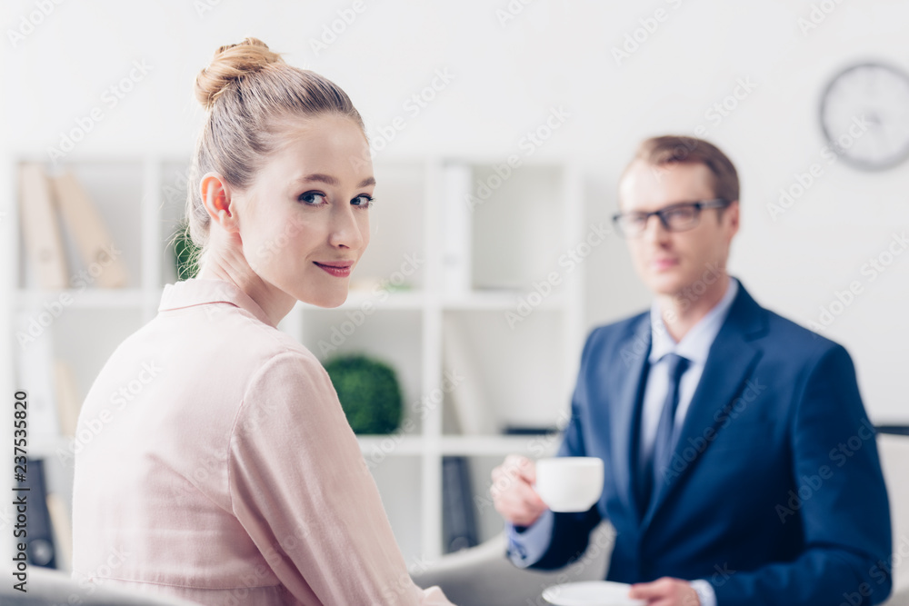 handsome businessman holding cup of tea, attractive journalist looking at camera in office handsome businessman holding cup of tea, attractive journalist looking at camera in office