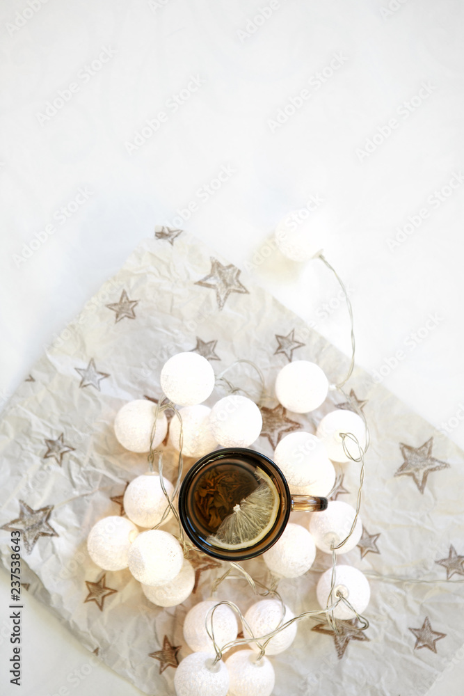 New Year's decoration. Green tea with lemon on a white background, healthy food, Christmas garland and the spirit of Christmas. New Year's decoration. Green tea with lemon on a white background, healthy food, Christmas garland and the spirit of Christmas.