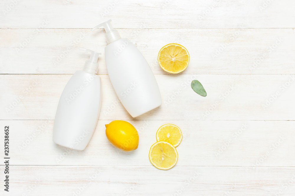 Whites Cosmetic bottle containers and fresh lemon on white wooden background top view flat lay copy space. Blank label for branding mock-up. Natural beauty product concept Shower Gel Soap Body Cream