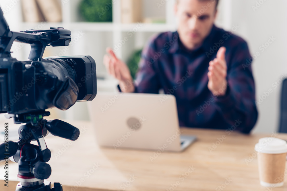 selective focus of male video blogger recording video blog and gesturing in office selective focus of male video blogger recording video blog and gesturing in office