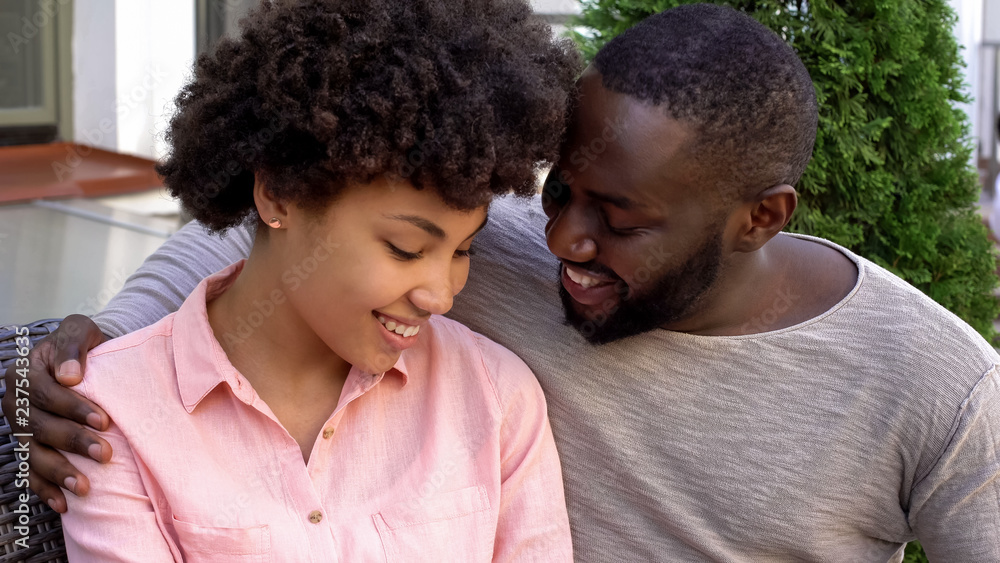 Smiling newlyweds looking each other with love, relaxing outside house, date Smiling newlyweds looking each other with love, relaxing outside house, date