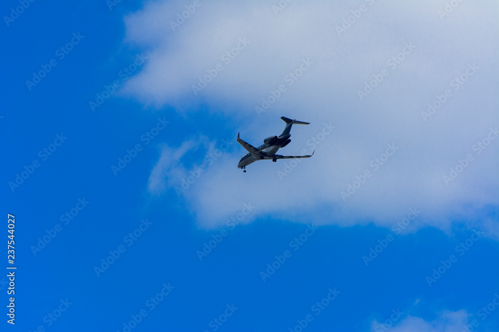 A large passenger airliner is a plane with a big wingspan high in the sky. Transport tourists for exotic holidays against the blue sky and white clouds A large passenger airliner is a plane with a big wingspan high in the sky. Transport tourists for exotic holidays against the blue sky and white clouds