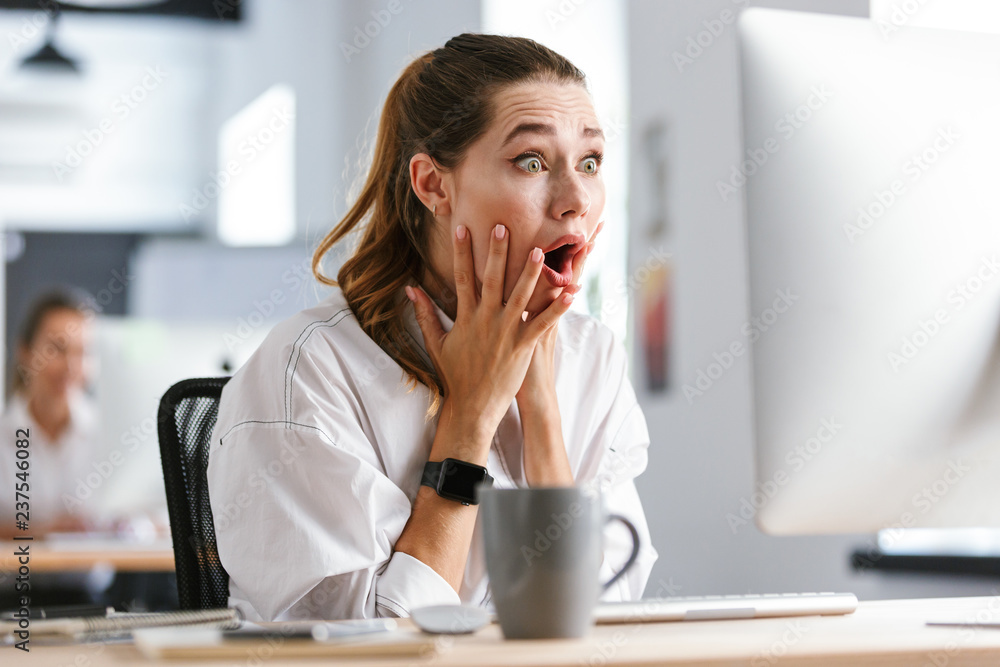 Shocked young woman dressed in shirt Shocked young woman dressed in shirt