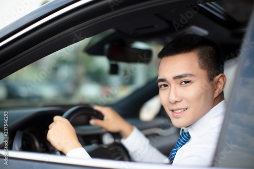 smiling young business man driving a car