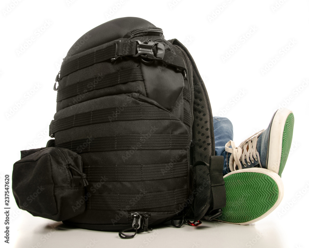 Man legs feet jeans sneakers with backpack on a white background. Isolation Man legs feet jeans sneakers with backpack on a white background. Isolation