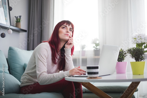 Woman at home using laptop and planning future