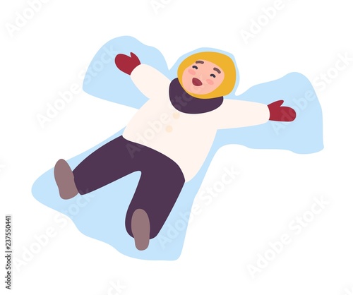 Laughing child lying on ground and making snow angel