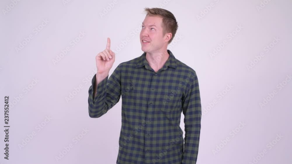 Young man showing copy space and pointing finger against white background Young man showing copy space and pointing finger against white background