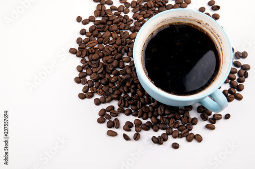 coffee mug with coffee beans on a white table, with copy space