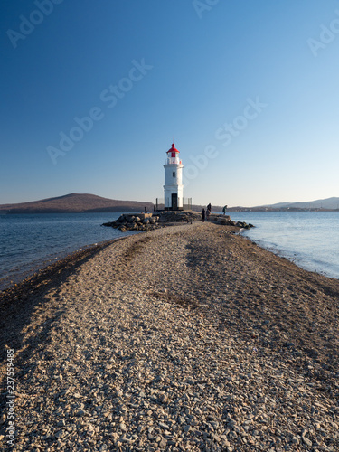 Tokarevsky lighthouse and people in the background of the Russian island of the Far Eastern city of Vladivostok. December, 2018 photo