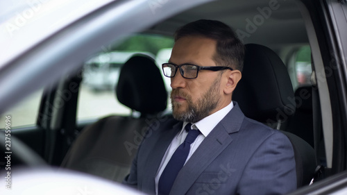 Serious businessman sitting in car, solitude before stressed work, day planning © motortion