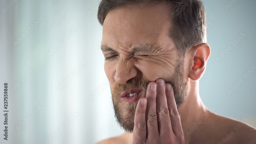 Male suffering from tooth ache, strong dental pain, pulp inflammation, decay Male suffering from tooth ache, strong dental pain, pulp inflammation, decay