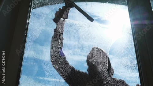 Caucasian man washes the wiper with a dirty window outside, slow mtion photo