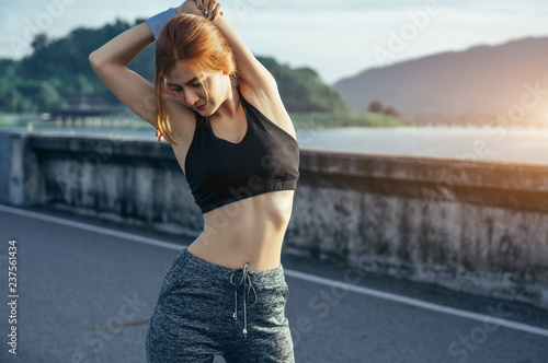 Asian woman is workout and running at the morning, she is warm up her body and drinking water. Healty and sport lifestyle concept.