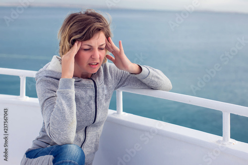 Foto Cruise sea motion sickness tourist woman seasick on boat vacation with headache or nausea