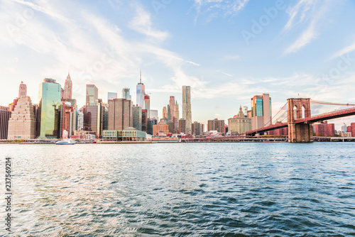 Outdooors view on NYC New York City Brooklyn Bridge Park by east river, cityscape skyline at sunset, skyscrapers, buildings, tour boat