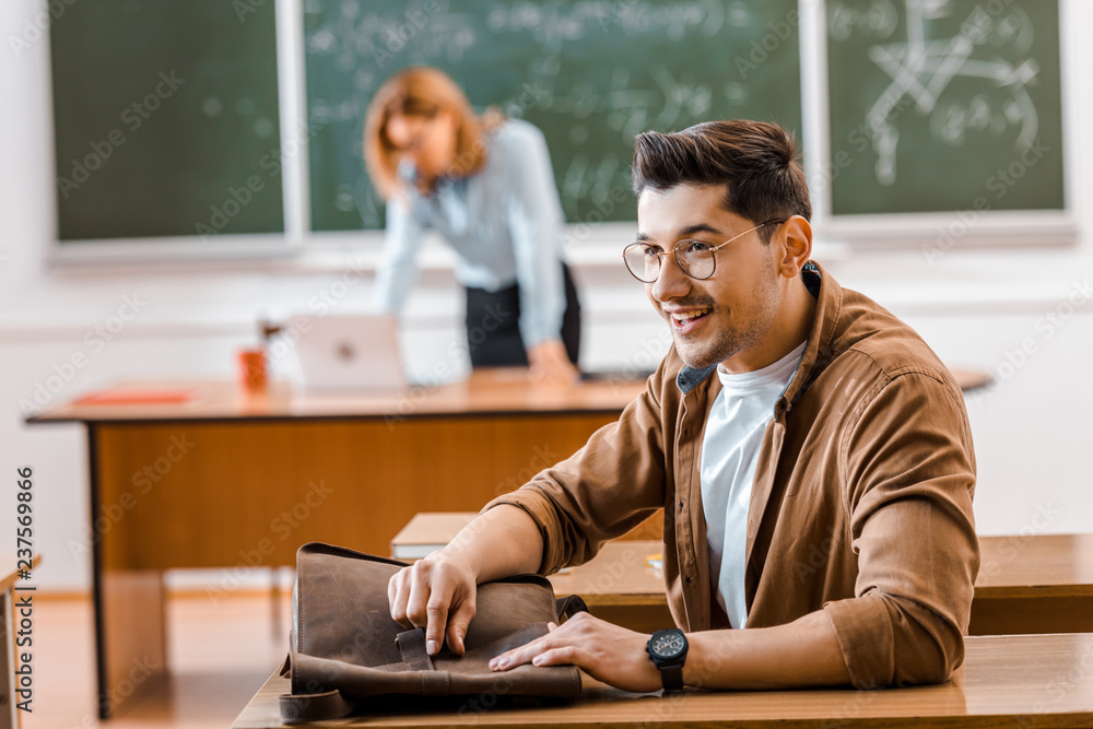 Selective focus of student in glasses with teacher on background Selective focus of student in glasses with teacher on background