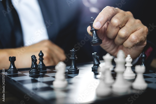 Businessman playing chess and thinking strategy about crash overthrow the opposite team and development analysis for win and successful
