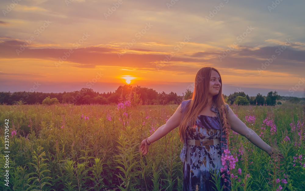 Obraz premium Beautiful girl smiling in a field of sunset