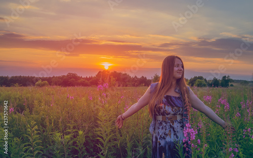 Beautiful girl smiling in a field of sunset