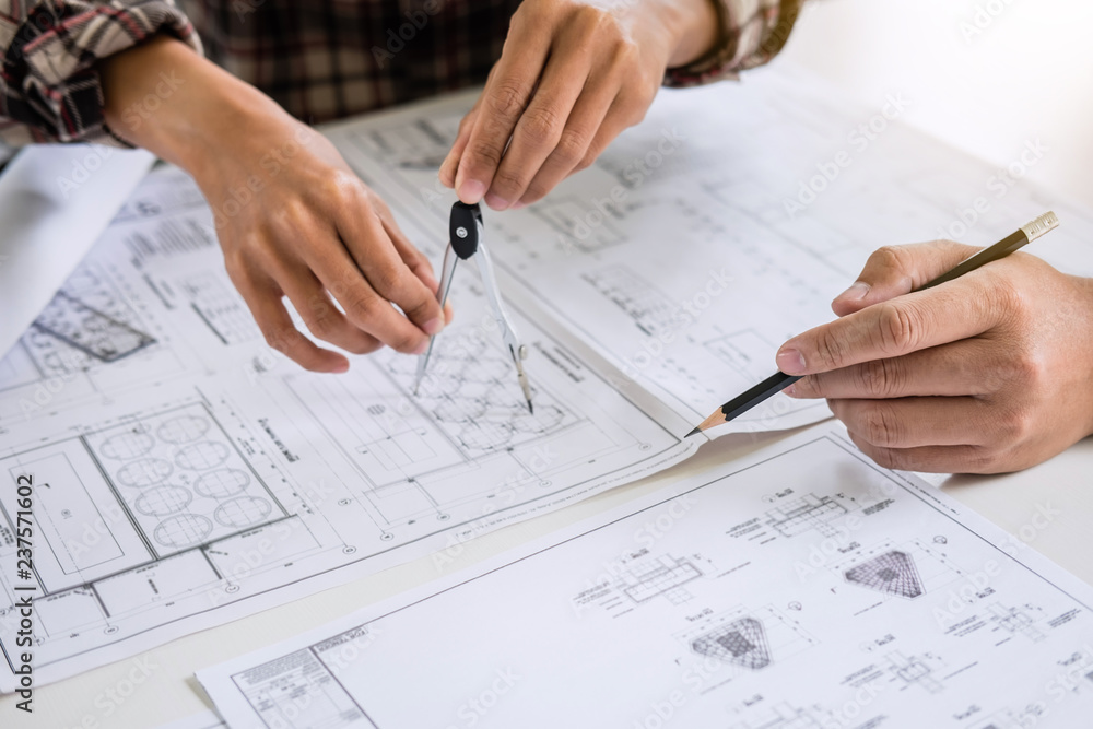 Construction engineering or architect discuss a blueprint while checking information on drawing and sketching meeting for architectural project in work site Construction engineering or architect discuss a blueprint while checking information on drawing and sketching meeting for architectural project in work site