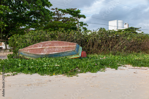 Wooden fishing boat, guarded in vegetation on the beach of Zimbros, Bombinhas, Santa Catarina photo