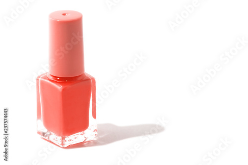 Trend photography on the theme of the actual colors for this season - a shade of orange. Isolated purple nail bottle on a white background.