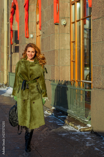 Stylish woman fashion model in winter coat walking in the city © millaf