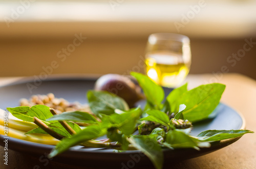 Fresh ingredients for preparing Italian pesto sauce - lemon basil sprigs, peeled seeds of cedar nuts, large garlic clove, Greek olive oil, Parmesan cheese photo