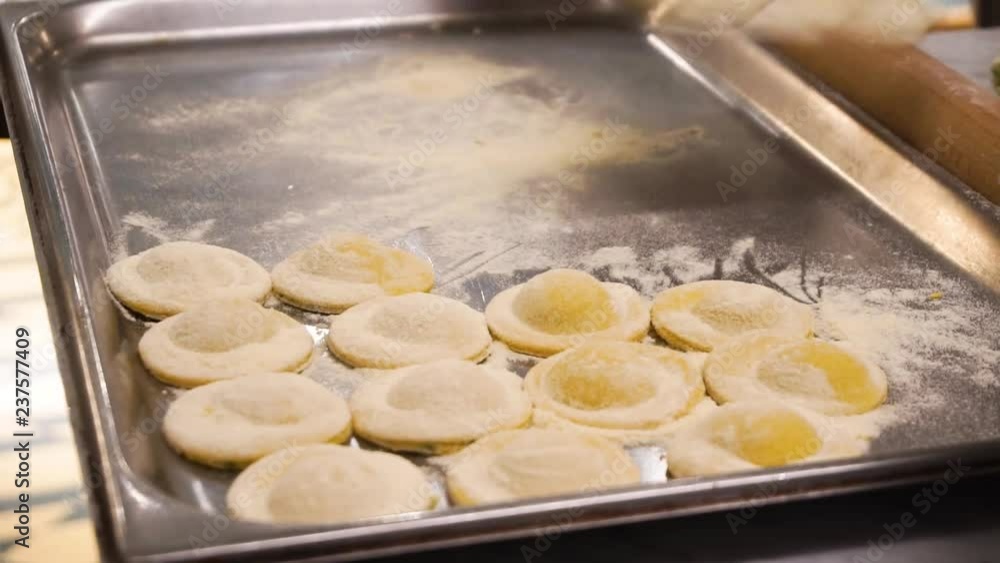 Ravioli in an Italian restaurant. Cook puts ravioli on a baking sheet. Ravioli in an Italian restaurant. Cook puts ravioli on a baking sheet.