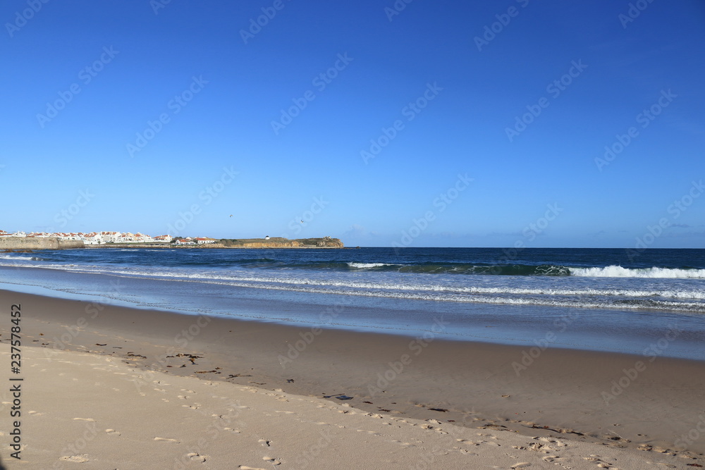 beach with wet sand and city in the background