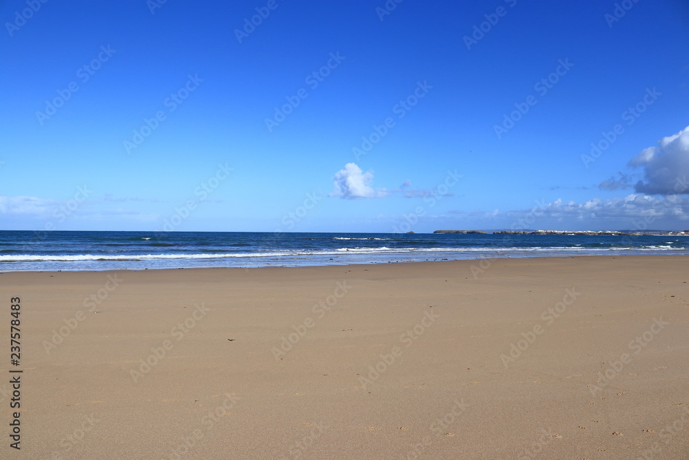 brown sand, dark blue sea and clear sky