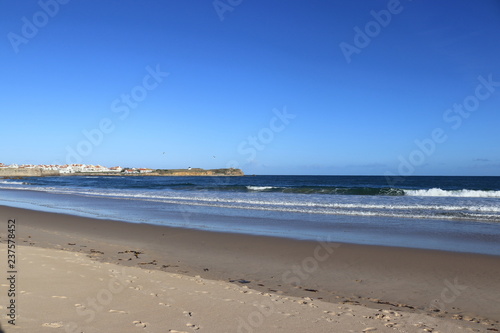 beach with wet sand and city in the background