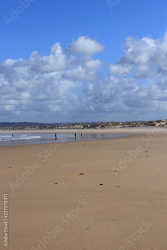 blue sky and clouds in the background, sand and people, Peniche