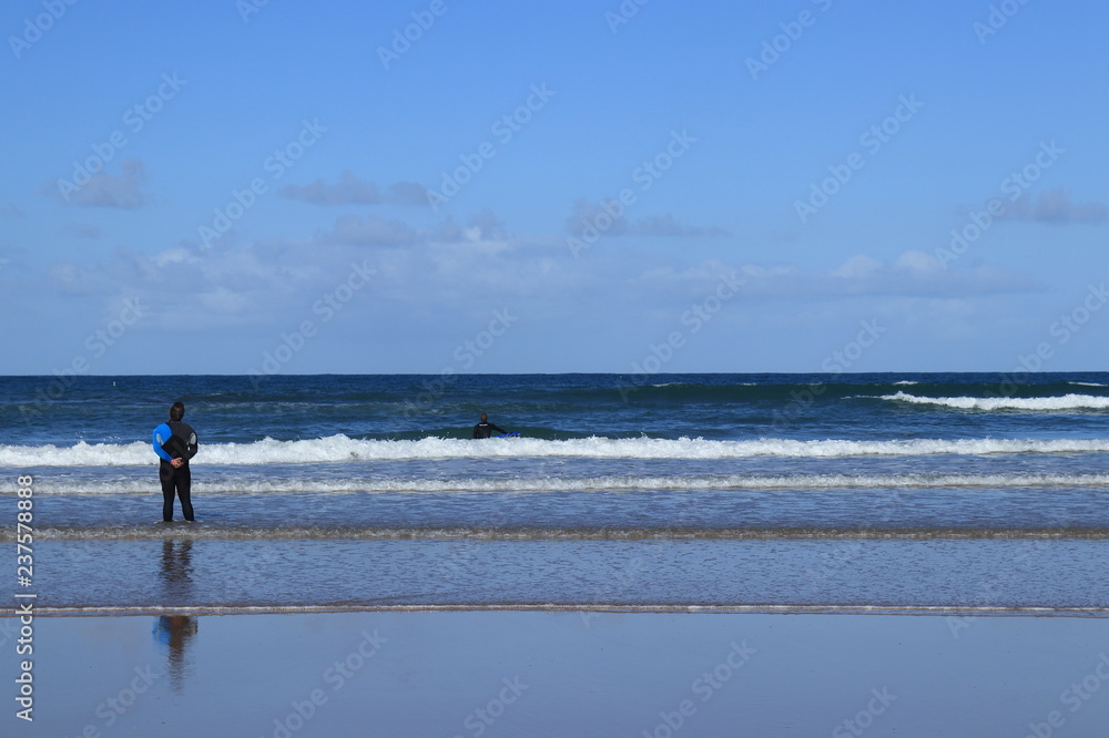 surf instructor giving directions to his student on the beach of Gamboa in Peniche