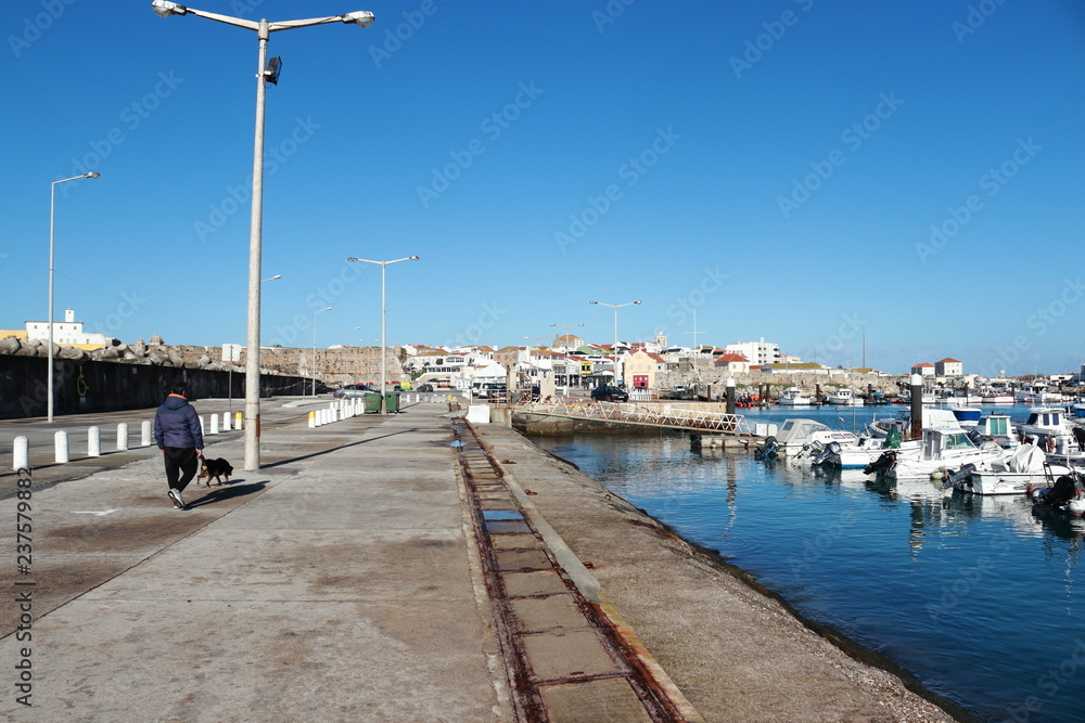 man walking the dog in the marina of Peniche
