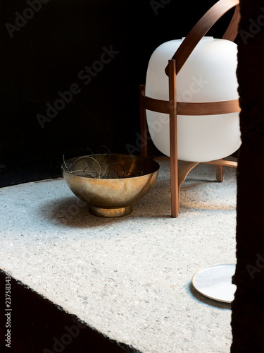 Weisse Lampe mit Holz und Gold Schale auf Steinregal photo