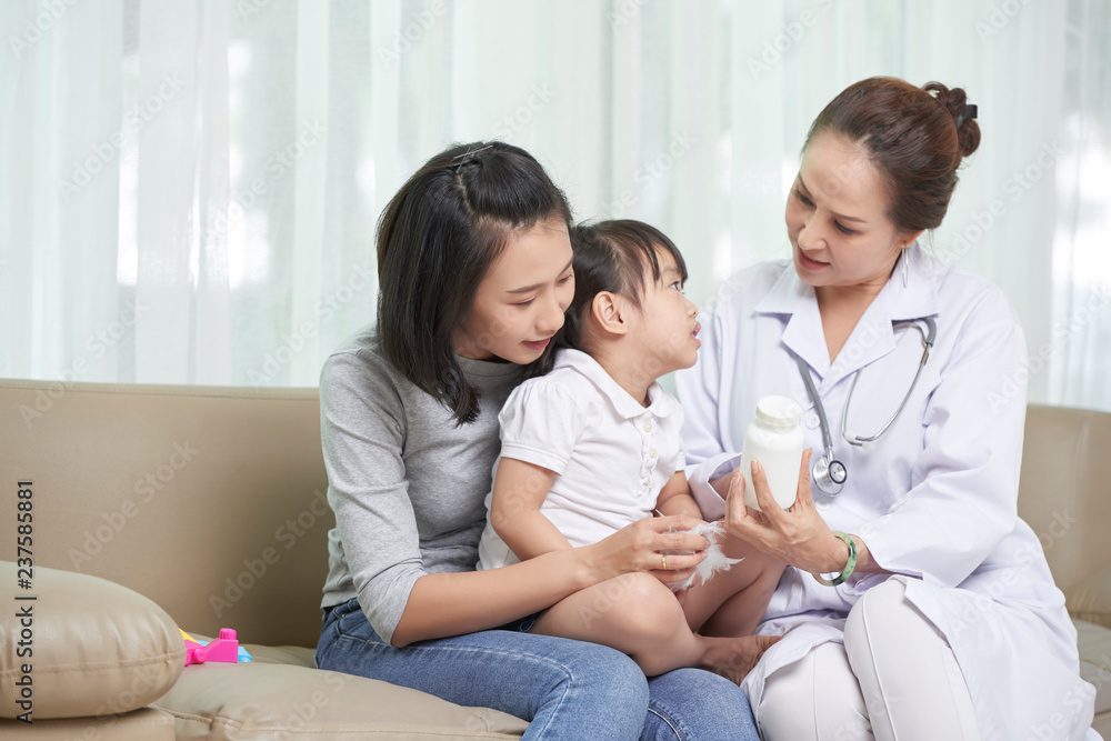 Φωτογραφία Pediatrician showing prescribed medicine mother and her little daughter