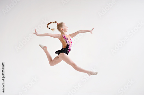 Llittle girl gymnast, performs various gymnastic and fitness exercises. A healthy lifestyle.