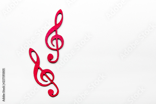 Red wooden treble clef on white background photo