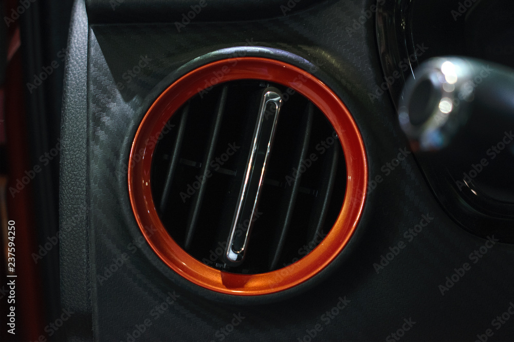 Obraz premium Car air ventilation, conditioner in orange circle. Ventilation deck in luxury modern car interior.