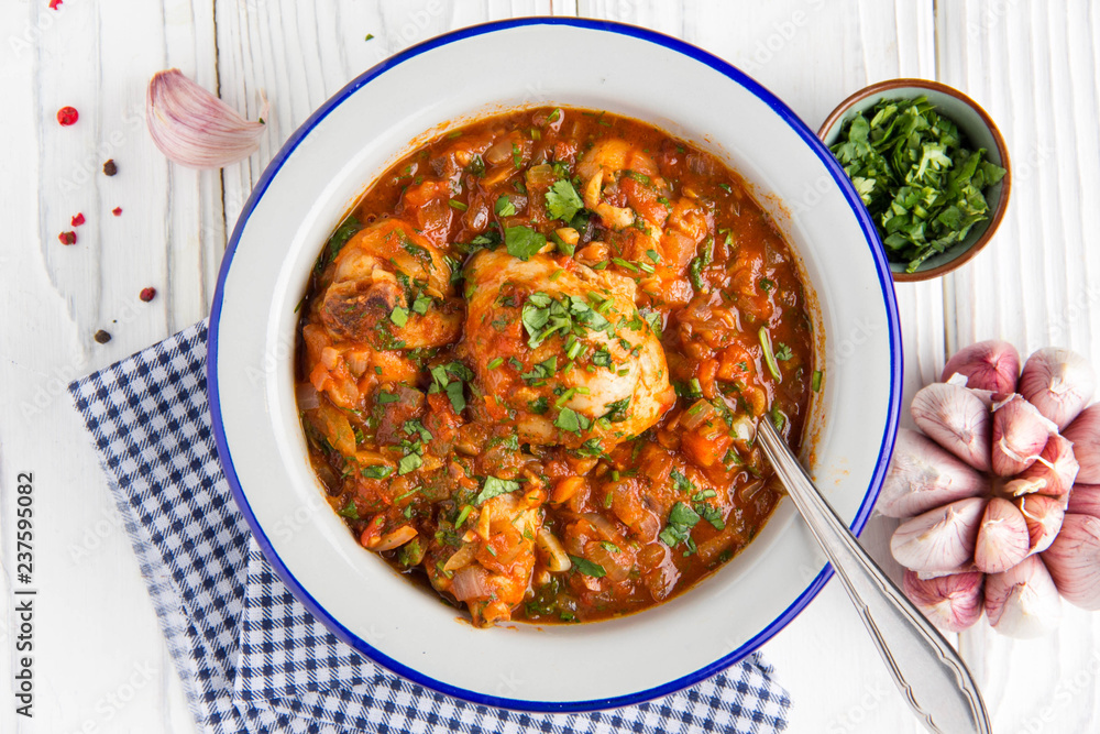 Chicken in tomato sauce with herbs and onions, cilantro parsley mint, traditional Oriental dish chakhokhbili, delicious homemade food. Chicken in tomato sauce with herbs and onions, cilantro parsley mint, traditional Oriental dish chakhokhbili, delicious homemade food.