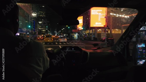 man driving across inner downtown Manhattan, New York, USA at night close to Times Square