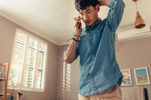 Man looking stressed while answering phone call © Jacob Lund